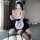 A woman poses in a black and white maid outfit, featuring lace details and stockings, capturing an elegant fantasy cosplay lo...