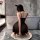 Woman in black feiniao moon gaze sexy sleepwear dress, sheer lace cami slip with alluring fit, kneeling on rug in modern bath...