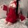 Woman kneeling in red feiniao moon-gazing hanfu lingerie set with sheer sleeves and embroidered doudou top.
