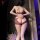Woman wearing feiniao moonbird sheer lace bodysuit with open-crotch design, back view in dim purple lighting.