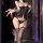 Woman modeling black feiniao moonlight lace bodysuit with sheer panels, front lacing, garter straps, and tight fit.