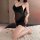 Woman wearing black feiniao moonlit bird lace chemise with floral embroidery, sheer bodycon fit, kneeling on white rug with r...