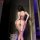 Woman wearing purple feiniao moonlit lace bodysuit, sheer mesh backless design with floral lace and garter straps.