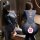 Woman modeling a black spider-themed bodysuit with dual zippers and open-crotch design, shown front and back views for role p...