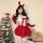 A woman poses beside a christmas tree wearing a festive red and white velvet costume, complete with reindeer antlers and a bo...