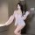 Woman modeling pink sheer lace princess sleepwear set with peekaboo chest detail and sensual bare-butt design.