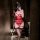 Woman in red lace lingerie set with sheer mesh and thigh-high stockings, taking a mirror selfie.