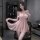 Woman modeling pink sheer lace nightgown with bow and pearl trim, flirty lingerie set for seductive sleepwear.