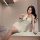 A woman poses with a teddy bear while wearing a flirty lace sleepwear set featuring adjustable straps, a cami top, and a skir...