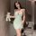 A woman poses with a teddy bear, wearing a light green lace sleepwear set featuring adjustable straps, a bow detail, and polk...