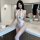 A woman poses confidently wearing a white lace bodysuit with cut-out chest design, underwire support, and bold bondage-inspir...