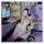A woman lounges in a gaming chair wearing a floral lace contrast sexy low-cut slip dress made from pure temptation satin-blen...