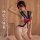 Woman modeling a white sailor-style bodysuit with blue trim, red bow, and side cut-outs for role play.