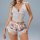 Woman wearing floral lace lingerie set with cami top and shorts, romantic sleepwear for women.