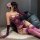 Woman wearing purple floral moon lace lingerie set with sheer back, long gloves, and thigh-highs in a sensual pose.
