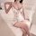 A woman sits on a bed wearing a floral pure-chic sleep dress featuring lace trim, bodycon design, and sleeveless style, perfe...