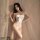Woman wearing flower moon seduction lingerie set – sexy white lace bodysuit with sheer cutouts, bow detail, and delicate stra...