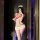 Woman in flybird moon gaze lingerie set, sexy nurse costume with skirt, posing in mirror with phone and bouquet.