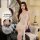 Woman wearing french-inspired lace sleep dress, sheer lingerie set with floral details, posing elegantly in bedroom setting.