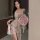 A woman wears a french-inspired lace sleep dress featuring vintage floral patterns, paired with a bouquet of pink roses, crea...