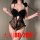 Woman wearing black french lace sheer bodysuit with butterfly knot detail, holding a feather wand.