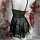 Black sheer chemise nightgown with lace trim and backless design, paired with matching thong, displayed on mannequin amidst r...