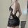 Woman wearing black sheer lace bodysuit with ties, featuring romantic french-style design for sensual vacation wear.