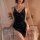 Woman wearing deep blue velvet sleep dress with lace trim and plunging neckline, styled with pearls in romantic bedroom setti...
