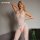 Woman modeling white glow-in-the-dark lace bodysuit with sheer mesh and open-crotch design, perfect for sexy nightwear.