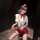 Woman in golden night air hostess lingerie set with sheer mesh, high-waisted skirt, and red accessories.