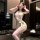 Woman modeling golden night lace lingerie set with eye mask, garter belt, and sheer stockings in elegant secretary style.