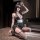 Woman in golden night nurse lingerie set with black dress, white belt, stockings, heels, and eye mask posing seductively.