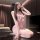 A woman poses elegantly in a pink lingerie set featuring a sensual butterfly design and sheer cup detail, highlighting its lu...