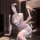 A woman poses elegantly in a sheer lavender lingerie set featuring a sensual butterfly design and delicate lace accents, hold...