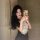 A woman takes a mirror selfie wearing a black gomeng lingerie set, featuring a catwoman bunny skirt with lace details and hea...