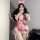 A woman poses with a shiny silk-look summer party outfit inspired by shen miao wei qing, featuring a pink corset, ruffled ski...