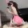 A woman wearing a pink leather cosplay costume with bunny ears, taking a selfie while sitting on a fluffy rug. the outfit fea...