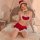 A woman poses on a bed wearing a festive santa hat and a heart-shaped christmas costume dress set. the ensemble features a sw...