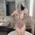 A woman poses in a bathroom wearing the hidden desire silk qipao lingerie, featuring high slits and vintage-inspired design e...