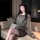 Woman wearing a hong kong style flirty pleated mini skirt with sensual bodycon lace trim and corset waistline, sitting on a c...