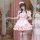 A cute girl wearing a japanese-style cosplay maid dress, featuring soft pink colors, ruffled details, and a charming apron de...