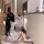 A woman sits on the floor wearing a japanese-style couples pajama set, featuring a floral kimono with butterfly accents and b...