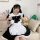 A woman wearing a japanese cute bunny maid cosplay dress, featuring black and white colors with lace details and a large bow....