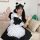 A woman wearing a japanese cute bunny maid cosplay dress, featuring black and white colors with ruffled details and a large b...