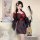 Woman modeling black floral japanese-inspired kimono lingerie set with red accents, holding fan beside pipa instrument.