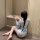 A woman sits on the floor wearing a japanese-inspired sheer kimono sleep dress, featuring an open front design with floral pa...