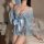 A woman wears a light blue japanese kimono-style lingerie set featuring floral patterns, a large bow detail at the waist, and...