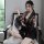 A woman sits on a chair wearing a japanese kimono-style lingerie set with floral patterns, featuring a deep v neckline and no...