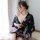 A woman wears a black floral japanese kimono-style lingerie set, featuring a plunging neckline and flowing sleeves, perfect f...