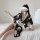 A woman sits on a bed wearing a black floral japanese kimono lingerie set, featuring a cloud mask and elegant design, perfect...